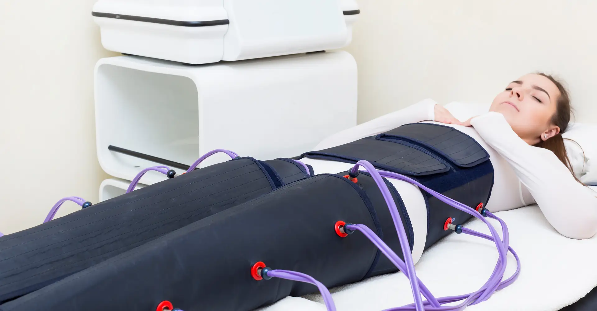 Ragazza vestita di Bianco con gli occhi chiusi che si sottopone alla pressoterpia medicale presso lo studio medico della dott.ssa Virginia De Simone